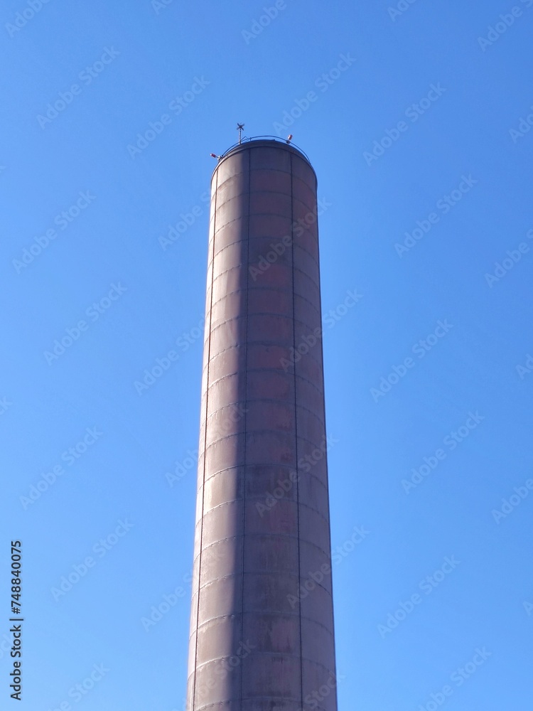 Industrial steel chimney on a sunny blue sky day