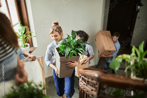 Group of people moving house with boxes and plants