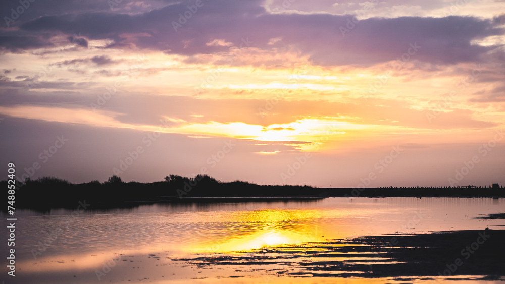 Lever du soleil et reflets sur l'eau d'une plage en camargue (près de Salin de Giraud)