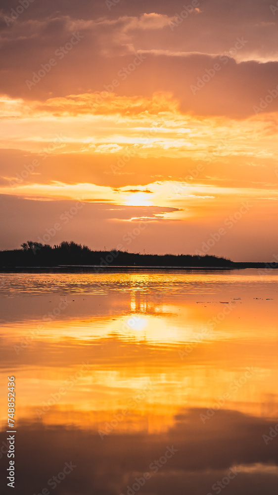 Lever du soleil et reflets sur l'eau d'une plage en camargue (près de Salin de Giraud)