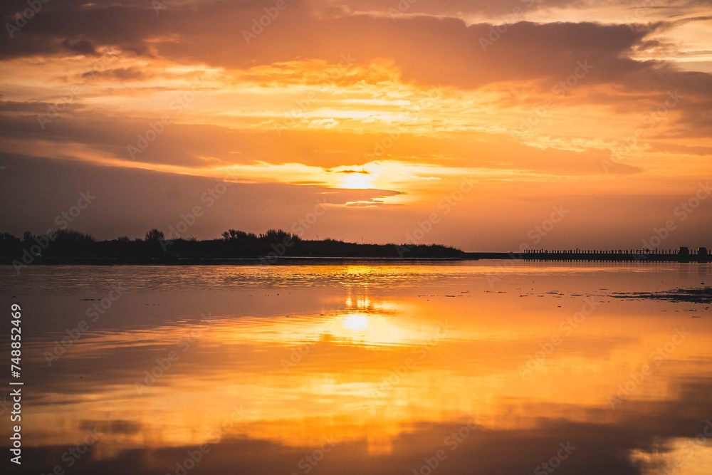 Lever du soleil et reflets sur l'eau d'une plage en camargue (près de Salin de Giraud)