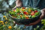 Freshly prepared organic salad in a ceramic bowl held by hands, showcasing freshness, health, and homemade cooking essence