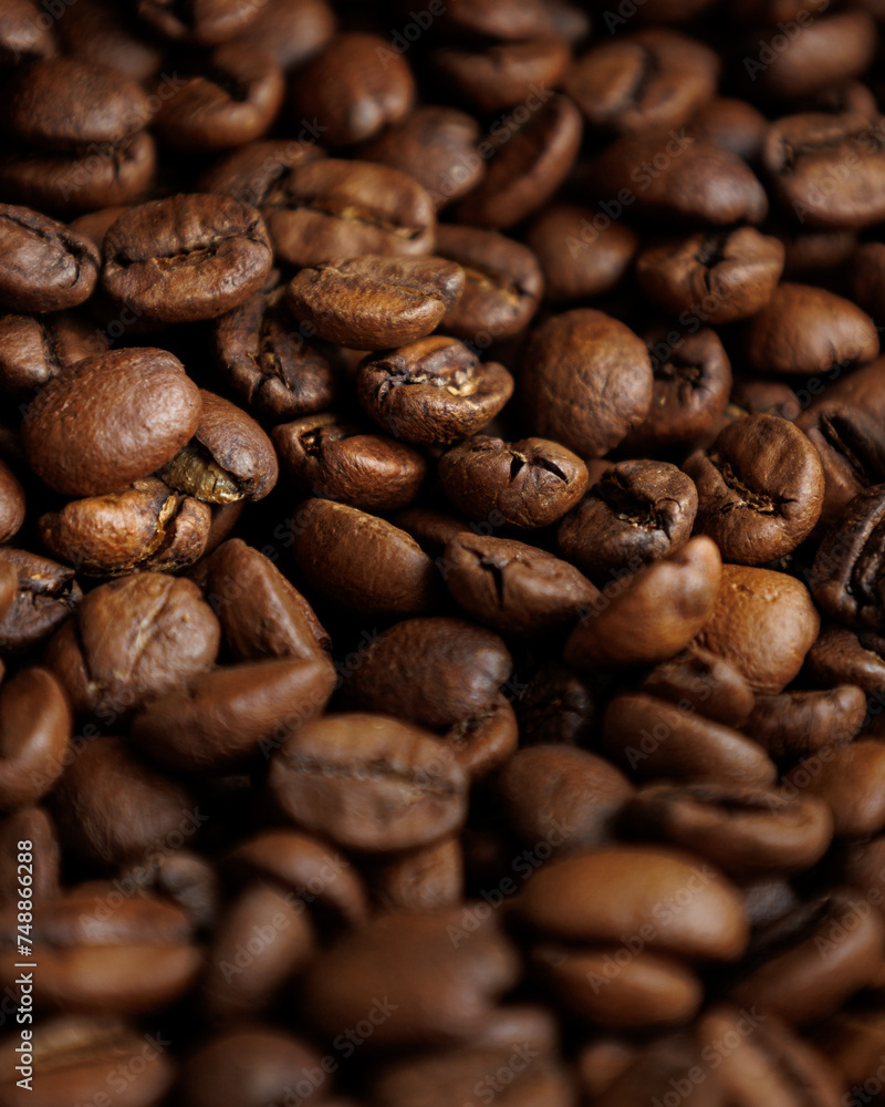 Fototapeta premium coffee beans are on table after roasting. Fresh converted coffee beans before packing in paper bag. Ground coffee for making Americano or cappuccino. grain cultivation and harvesting