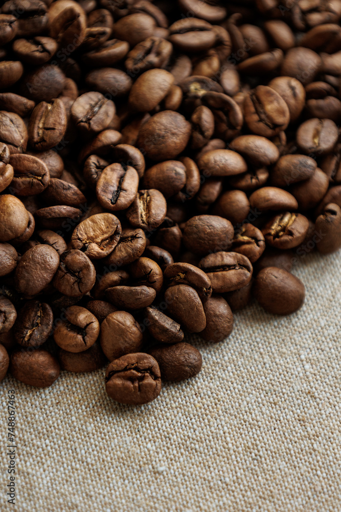 Fototapeta premium coffee beans are on table after roasting. Fresh converted coffee beans before packing in paper bag. Ground coffee for making Americano or cappuccino. grain cultivation and harvesting