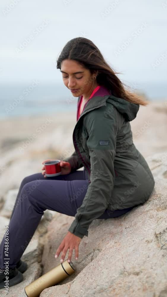 young latin woman traveler sitting alone in the mountain enjoying coffee and nature young latin woman traveler sitting alone in the mountain enjoying coffee and nature