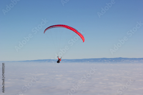 Paragliding. Paragliding in Auvergne. paragliding flight in the mountains in France. Paragliding over the clouds. Sea of clouds and paraglider. Panorama of the mountains. Puy de Dôme