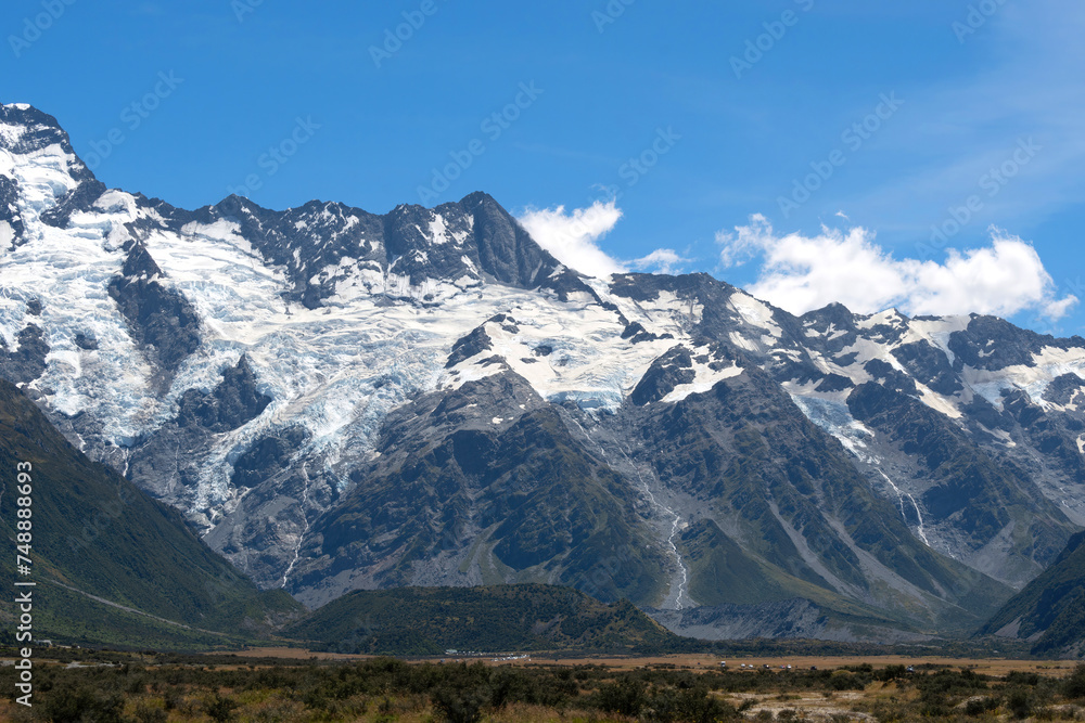The massive mountains with glacier in a peaceful summer day with fresh blue sky at Mount Cook National Park, New Zealand.