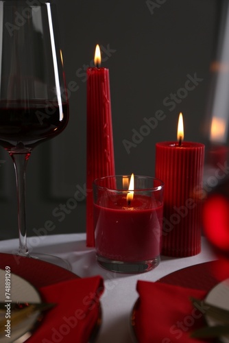 Place setting with red candles on white table. Romantic dinner