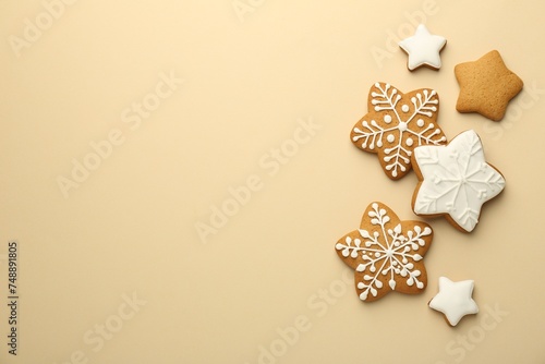 Tasty Christmas cookies with icing on beige background  flat lay. Space for text