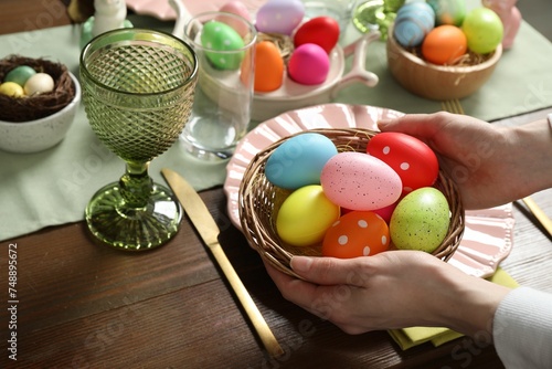 Woman setting table for festive Easter dinner at home, closeup