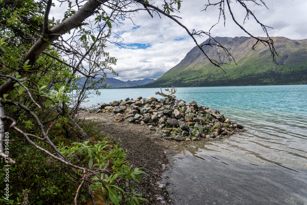 Rock jetty on Upper Twin Lakes at Dick Proenneke's cabin site at Lake Clark National Park. Rock piles offer wind protection for float plane docking. Caribou antlers and skull Rock jetty on Upper Twin Lakes at Dick Proenneke's cabin site at Lake Clark National Park. Rock piles offer wind protection for float plane docking. Caribou antlers and skull