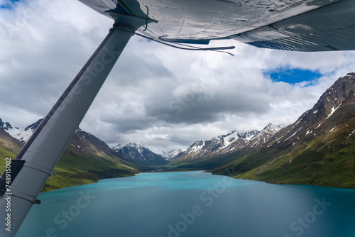 Point of View (POV) from under the wing of a Cessna fixed wing airplane with seaplane wing rope. Flying over Upper Twin Lake, Twin Lakes in Lake Clark National Park, Alaskan wilderness. 