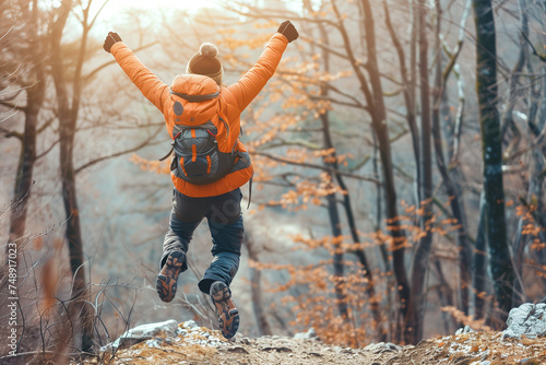  Happy man with arms up jumping on the top of the mountain - Successful hiker celebrating success on the cliff - Life style concept with young male climbing in the forest pathway