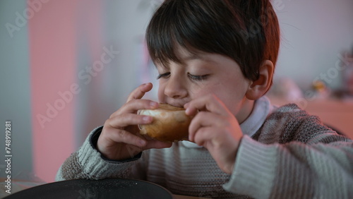 Little Boy Eating Bread at Table  Taking a Bite of Carb Food