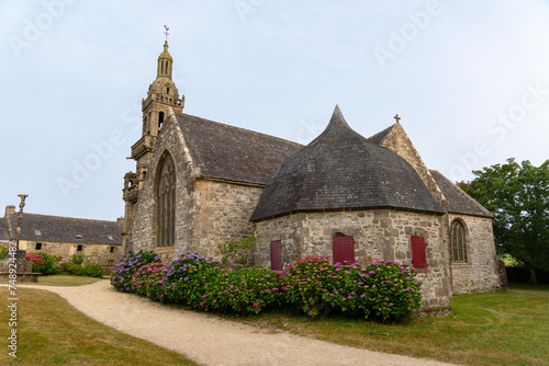 En été, les massifs d'hortensias en fleurs bordant le mur de la chapelle offrent un spectacle estival éclatant, illuminant le paysage breton de leur beauté colorée.
