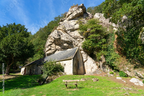 La chapelle Saint-Gildas à Pluméliau-Bieuzy est nichée sous un énorme rocher de granit, fusionnant spiritualité et majesté naturelle en Bretagne.