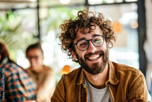 Portrait of a jovial man with curly hair and glasses smiling, evoking happiness and positivity photo