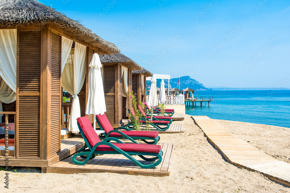 Fototapeta premium Wooden beach pavilions on the shore of a sandy beach