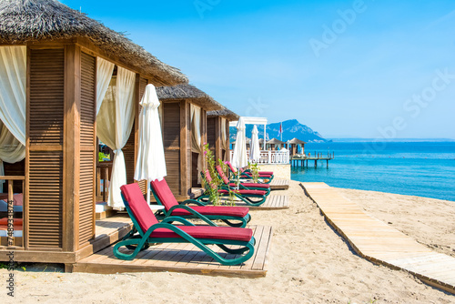 Wooden beach pavilions on the shore of a sandy beach photo