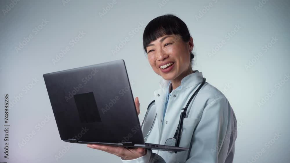 Medium shot of middle-aged Asian female doctor or GP talk consult client online on computer, woman nurse speak with sick patient on video call use Webcam conference on laptop Medium shot of middle-aged Asian female doctor or GP talk consult client online on computer, woman nurse speak with sick patient on video call use Webcam conference on laptop