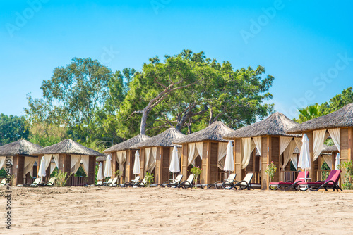 Wooden beach pavilions on the shore of a sandy beach