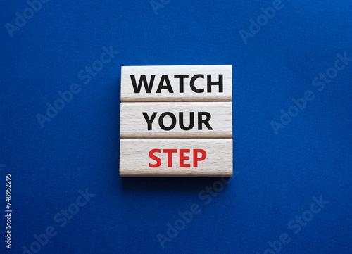 Watch your Step symbol. Concept words Watch your Step on wooden blocks. Beautiful deep blue background. Business and Watch your Step concept. Copy space. © Natallia