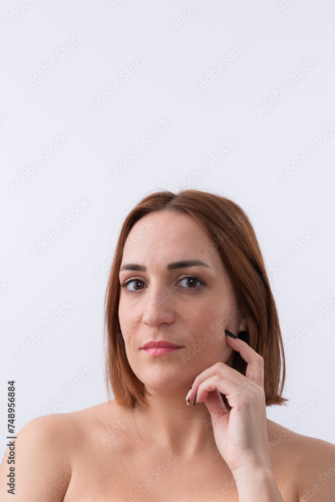 Portrait of 30 years old beautiful woman with short red hair and hand on her face looking at camera isolated on white background. Copy space. Natural beauty concept Portrait of 30 years old beautiful woman with short red hair and hand on her face looking at camera isolated on white background. Copy space. Natural beauty concept