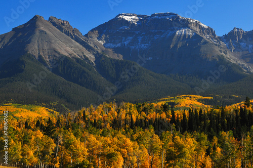 Late afternoon light on fall colors up the slopes of Whitehouse Mountain and Corbett Peak and ridge on the Sneffels Range of the San Juan mountains, from a country road near Ridgway, Colorado, USA. photo