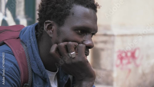 depression, frustration -sad black man sitting on the street thinking photo