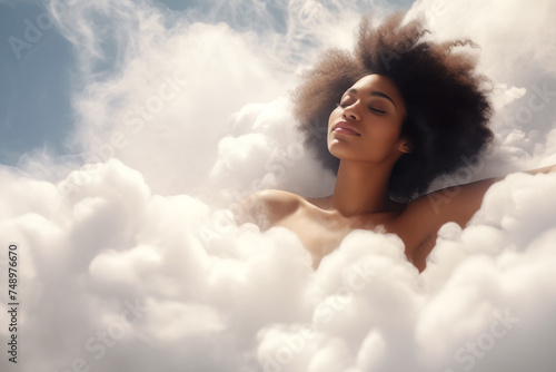 Young attractive sleepy Afro-American woman with closed eyes relaxing in clouds like in bath foam. Concept of spa, relaxing in white soft white clouds. Dreaming, calm, harmony, mental health concept.