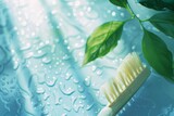 A close-up image of a toothbrush laid on a glistening wet surface with fresh green leaves conveying a sense of cleanliness and hygiene