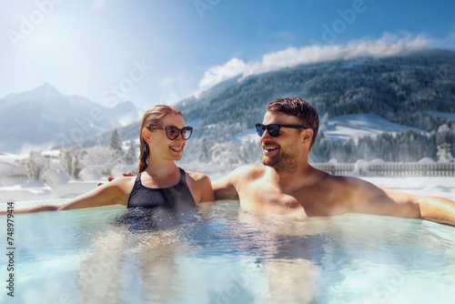 Valokuva happy couple relaxing in outdoor hot tub at ski spa resort