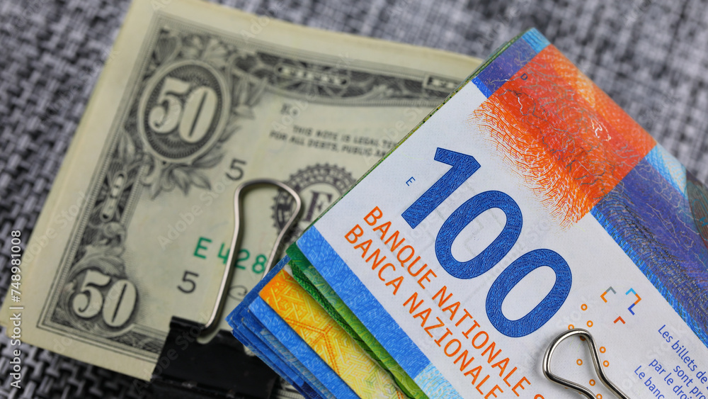 Obraz premium Half-folded Swiss franc and US dollar banknotes