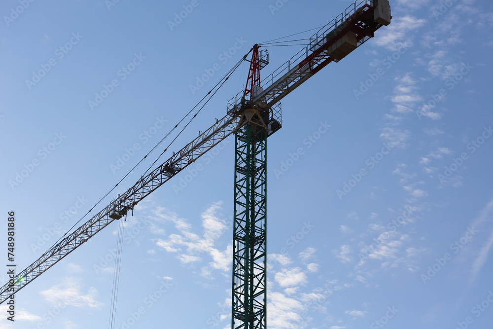 Tall tower crane against blue sky