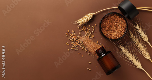 wheatgerm skincare products with grains, crushed bran and brown glass bottles on brown backdrop, free space for text 