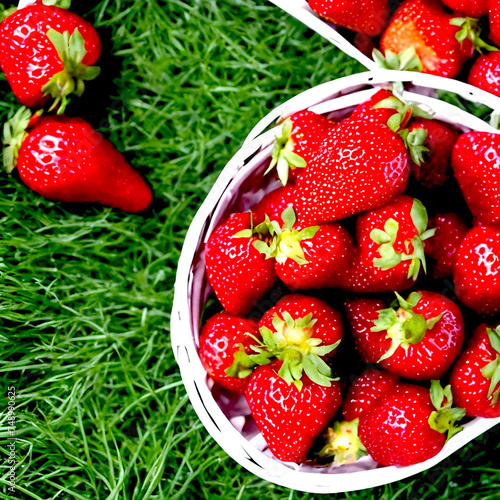 eap of fresh strawberries in bowl on white wooden background. Top view point. photo