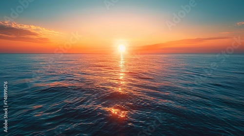 Sunset on the horizon, with the sun casting a warm glow over the sky and the sea