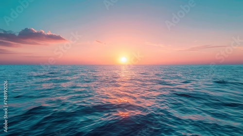 Sunset on the horizon, with the sun casting a warm glow over the sky and the sea