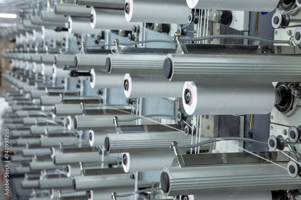Factory equipment in perspective. Rows with coils of polypropylene threads for weaving cloth. Automatic machine. Nobody. Factory equipment in perspective. Rows with coils of polypropylene threads for weaving cloth. Automatic machine. Nobody.