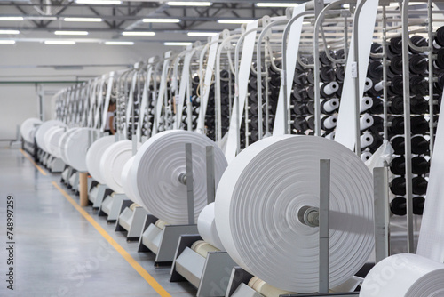Factory. Interior of a factory workshop for the production of polypropylene bags. Racks with rolls and coils. Without people.