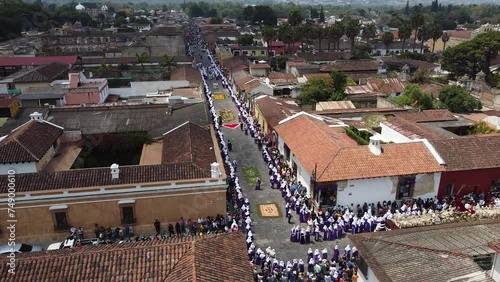 Antigua, Guatemala, Lent procession walks over dyed sawdust carpet in colonial town & UNESCO World Heritage Site with most famous Holy Week celebrations . Semana Santa Drone shot, aerial view