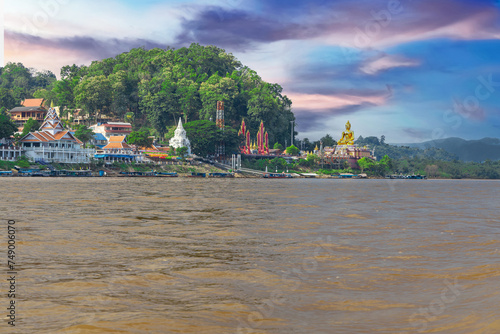 Golden Triangle the 3 borders of Thailand Laos and Myanmar lovely Golden Buddha on the Mekong River with boats in the river and mountains in the background  photo