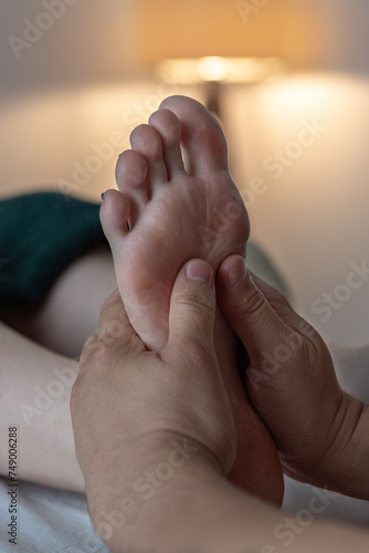 Foot massage. Massage of  foot in spa salon - Soft focus image, hands of massage therapist. Health and beauty, relaxing treatment