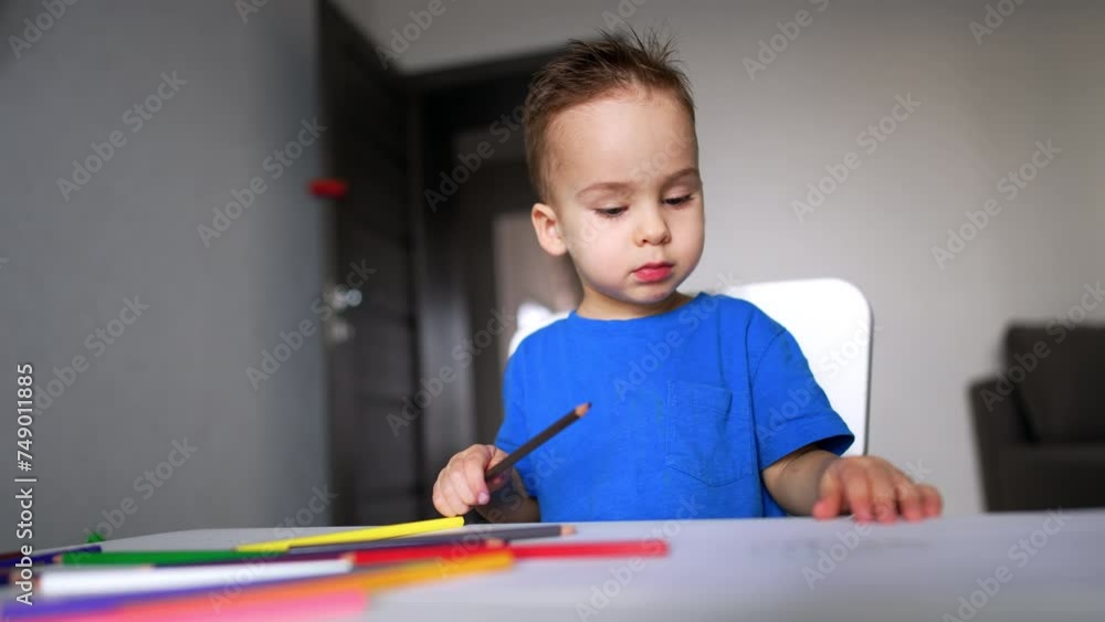 Cute playful boy painting with pencils. Little cute boy drawing concept. Cute playful boy painting with pencils. Little cute boy drawing concept.