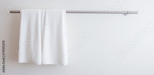a white towel rod hung on a white bathroom wall