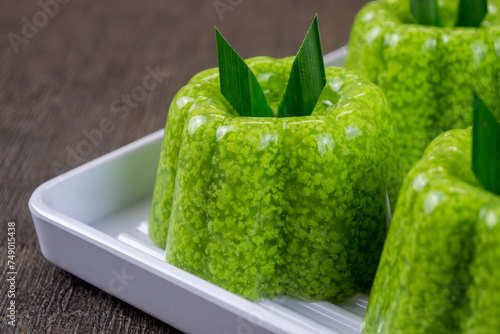 pudding lumut or moss pudding served on a white plate with pandan leaves on top. Very fresh and healthy food photo