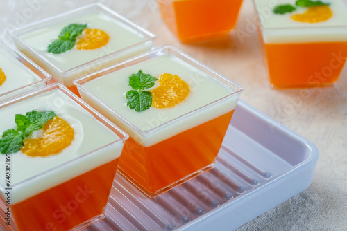 pudding jeruk vla susu or orange pudding topped with milk vla sauce, orange slices and mint leaves. Very fresh and healthy