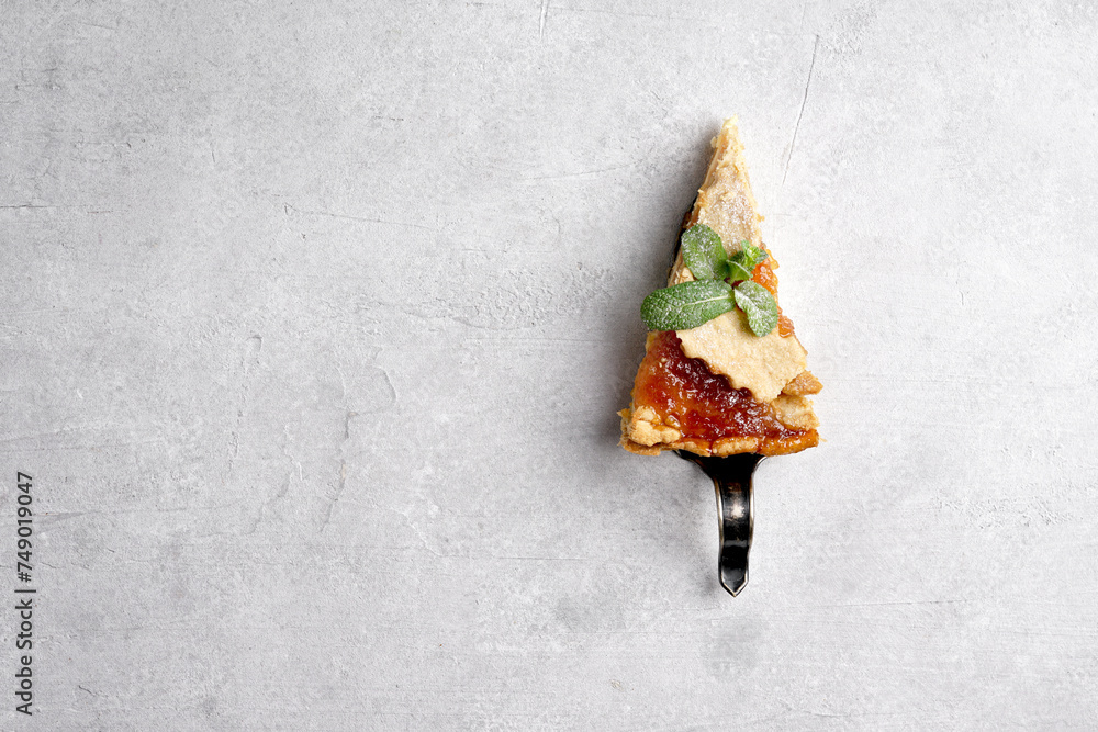 A piece of pie , cake with apple jam on a grey stone background. Copy space. Top view. A piece of pie , cake with apple jam on a grey stone background. Copy space. Top view.