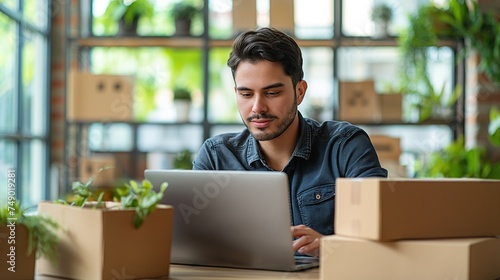 Business owner Start up of enterprise small using laptop at workplace small business entrepreneur SME or freelance working with a box at home deliver to customers, Online selling or e-commerce. © armensl