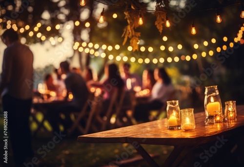 people sit at an outdoor party with string lights up